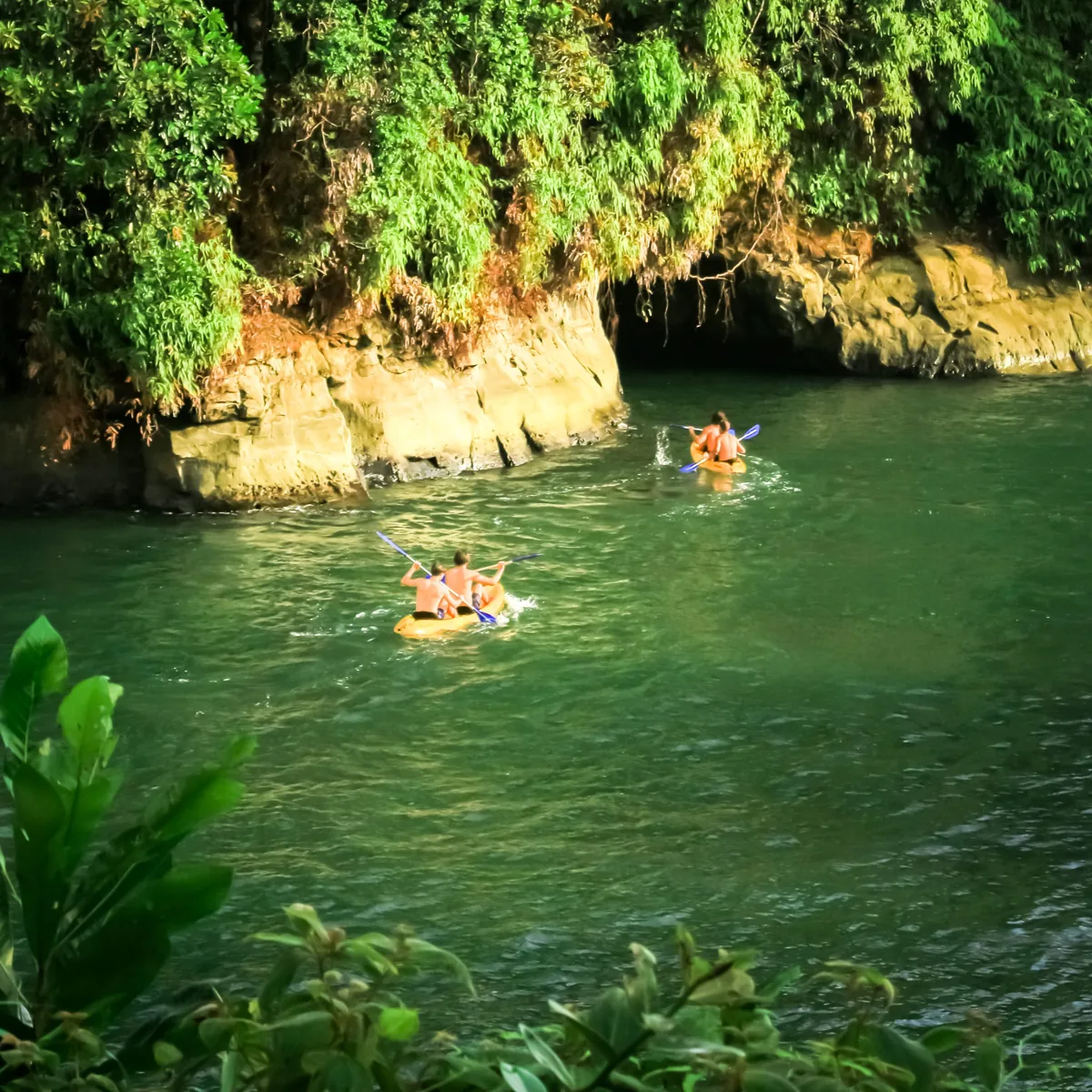 Marea alta en Playa Escondida: el agua llena el estero junto a las rocas y la cueva